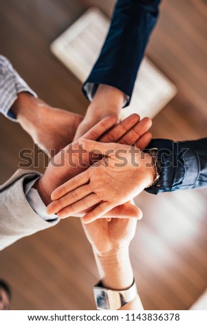 Close-up image of stack of hands. Bottom view. Business success concept.