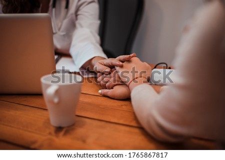 Close-up image of supporting hands of friendly general practitioner.