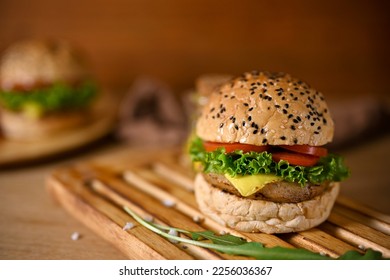 Close-up image of tasty beef burger on rustic wooden tray, beef burger with cheese. American fast food concept - Shutterstock ID 2256036367