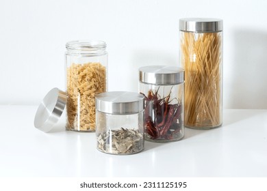 A close-up image of three glass jars, filled with various dried ingredients, sitting atop a white countertop - Powered by Shutterstock