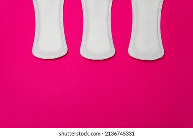 Close-up image of three women's sanitary napkins on a pink background leaving copy space. Concept of intimate hygiene of the woman when she is with the period.