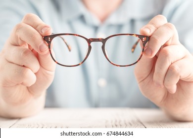 Closeup image: two hands holding classic glasses