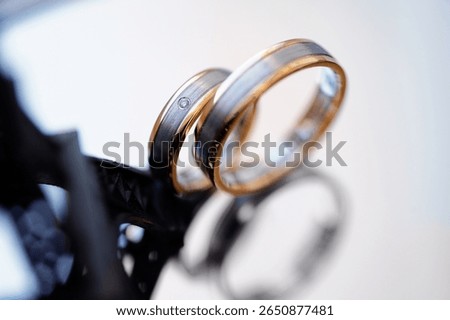 Close-up image of two intertwined wedding rings, symbolizing unity, love, and eternal commitment in a clear setting. A meaningful depiction of an important life milestone and celebration of romance.