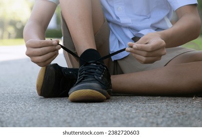 Closeup image of tying shoelace getting ready for exercise afterschool of asian schoolboy, concept of preventing the risk of falls of all people around the world. - Powered by Shutterstock