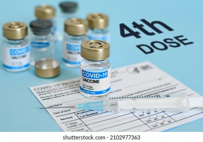 Close-up image of vaccine vial and syringe on CDC covid-19 vaccination record card  Fourth or 4th dose text on blue background  - Shutterstock ID 2102977363