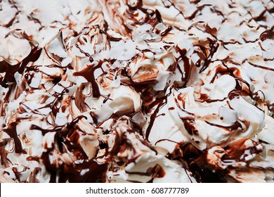 A Closeup Image Of Vanilla Ice Cream Texture With Chocolate And Caramel Toppings, And Coconut Chips.