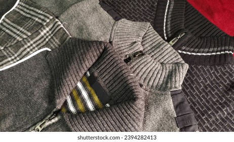 Close-up image of a variety of woollen jacket sweaters with chains and collars lying on a surface - Powered by Shutterstock