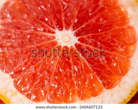  Close-up image of a vibrant grapefruit slice showing detailed pulp and segments in a radial pattern, emphasizing freshness and texture.