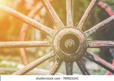 Closeup image of a vintage colored carriage wheels  with golden glow from the sun