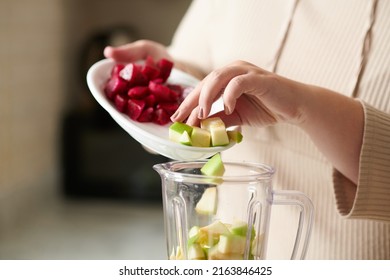 Close-up Image Of Woman Adding Green Apple And Dragonfruit In Blender When Making Smoothie