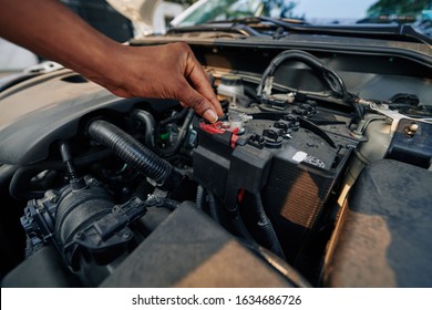 Close-up Image Of Woman Checking Or Changing Car Battery