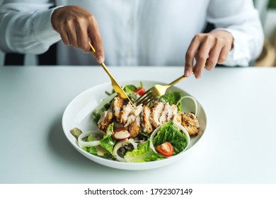 Closeup Image Of A Woman Eating Chicken Salad On Table In The Restaurant