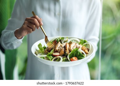 Closeup Image Of A Woman Holding And Eating Chicken Salad 