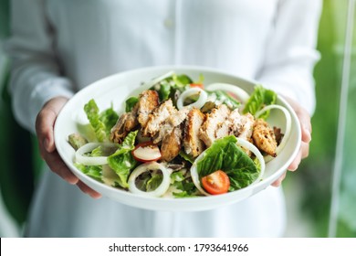 Closeup Image Of A Woman Holding A Plate Of Chicken Salad 