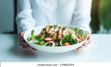 Closeup Image Of A Woman Holding A Plate Of Chicken Salad 