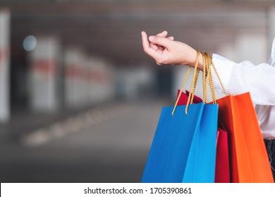 Closeup Image Of A Woman Holding Shopping Bags In The Mall Parking Lot