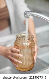 Close-up Image Of Woman Pouring Fresh Water In Glass Vase