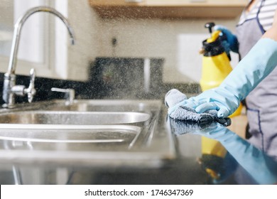 Close-up Image Of Woman Spraying Disinfecting Detergent On Kitchen Counter And Sink To Kill All Bacteria