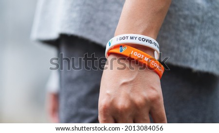 Closeup image of a woman wearing I got my covid-19 vaccine wristband for health care concept