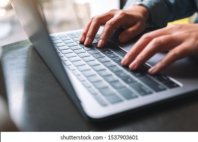 Closeup image of a woman working and typing on laptop computer keyboard 