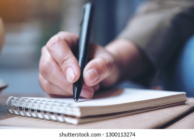 Closeup image of a woman's hand writing on blank notebook  - Shutterstock ID 1300113274