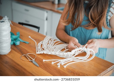 Close-up image of a woman's hands doing macramé. Concept of wom