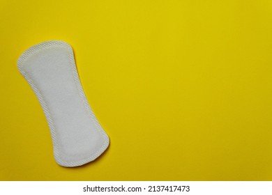 Close-up image of a women's sanitary napkin on a yellow background leaving copy space. Concept of intimate hygiene of the woman when she is with the period.