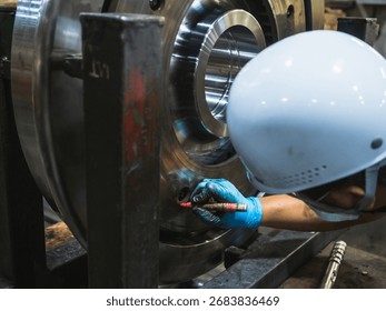 close-up image worker hand assembling or inspecting large industrial machine component. metal part features multiple circular holes and bolt, suggesting part of  collaborative  safety environment - Powered by Shutterstock - Get 15% off with code: PIKWIZARD15