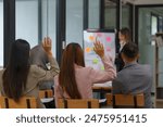 Close-up image of a young businesswoman raising her hand to ask a question during the meeting with her team. business meeting, training, consultation, seminar.