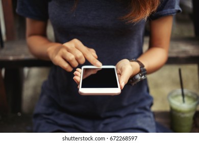 Close-up image of young hipster girl using modern smartphone device.