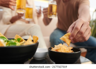 Close-up Image Of Young People Having Corn Chips While Drinking Beer In Bar