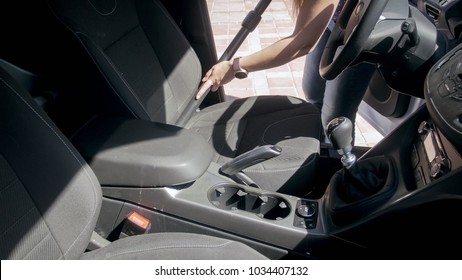 Closeup Image Of Young Woman Cleaning Dirty And Messy Car With Vacuum Cleaner