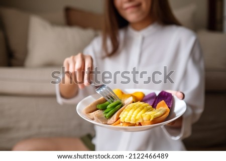 Closeup image of a young woman eating vegetables, Vegan, Clean food, dieting concept