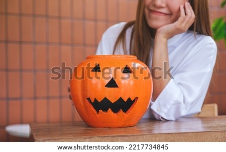 Closeup image of a young woman with a Halloween pumpkin bowl for Halloween festival concept
