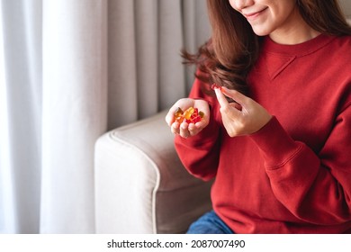 Closeup image of a young woman holding and eating jelly gummy bears