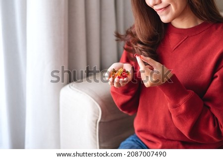 Closeup image of a young woman holding and eating jelly gummy bears