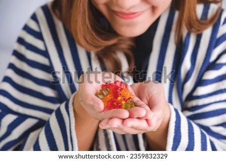 Closeup image of a young woman holding jelly gummy bears