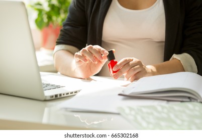 Closeup Image Of Young Woman Painting Fingernails At Office