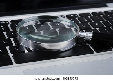 Closeup Images Of Magnifying Glass On Laptop Keyboard, Searching, Online Shopping, And Business Concept