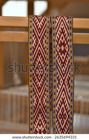 Close-up images showcasing the intricate process of traditional band weaving on a wooden loom. Colorful threads are woven into vibrant, geometric patterns typical of Baltic belts.