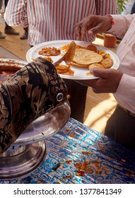  Closeup of Indian street food vendor serving vegetable curry from  bowl                              