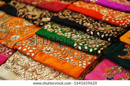 Closeup of Indian woman Salwar Kameez dress material stacked display in a retail shop                              