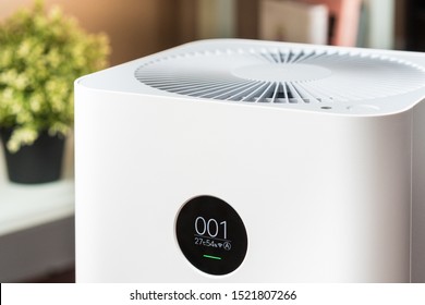 Closeup Of An Indoor Air Purifier With Monitor Screen That Show Air Quality In The Room Is Very Safe And Clean To Breathe While Dust Air Pollution Situation Outside Is Really Bad. PM 2.5, Healthy.