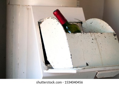 Close-up Indoor Shot Of A Wine Bottle In A Garbage Chute