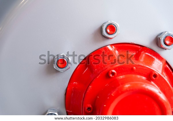 Close-up of industiral machine rim with screws and\
red hub
