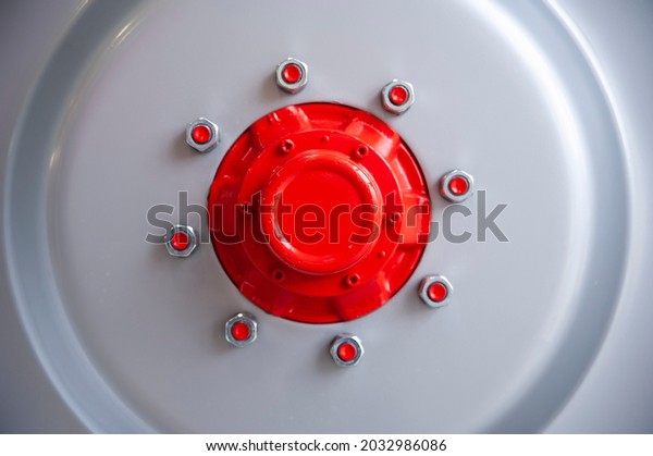 Close-up of industiral machine rim with screws and
red hub