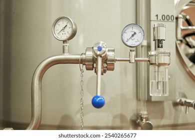 Close-up of an industrial stainless steel pressure gauge with valves and controls - Powered by Shutterstock