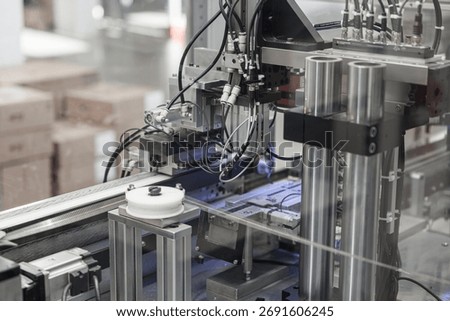 Close-up of an industrial wire processing machine featuring rollers, pneumatic actuators, and numerous cables in a high-tech automation system. Includes copy space