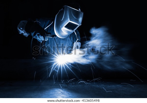 Closeup industrial Worker at the\
factory welding, Worker welding at industrial\
factory.