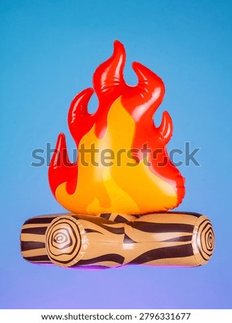 Close-up of an inflatable campfire with logs on a purple background, showcasing its bright colors and playful design